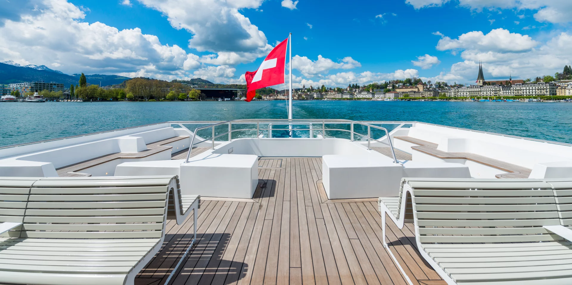 Schiff mit Schweizerfahne auf dem Vierwaldstättersee verlässt den Steg 